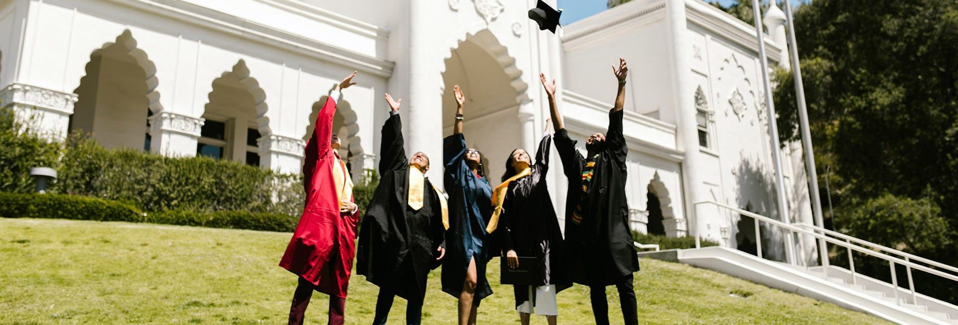 graduates throwing cap and gown